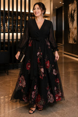 Plus size black floral evening dress with sheer long sleeves, flattering V-neckline, raised waist and flowing A-line skirt front view.