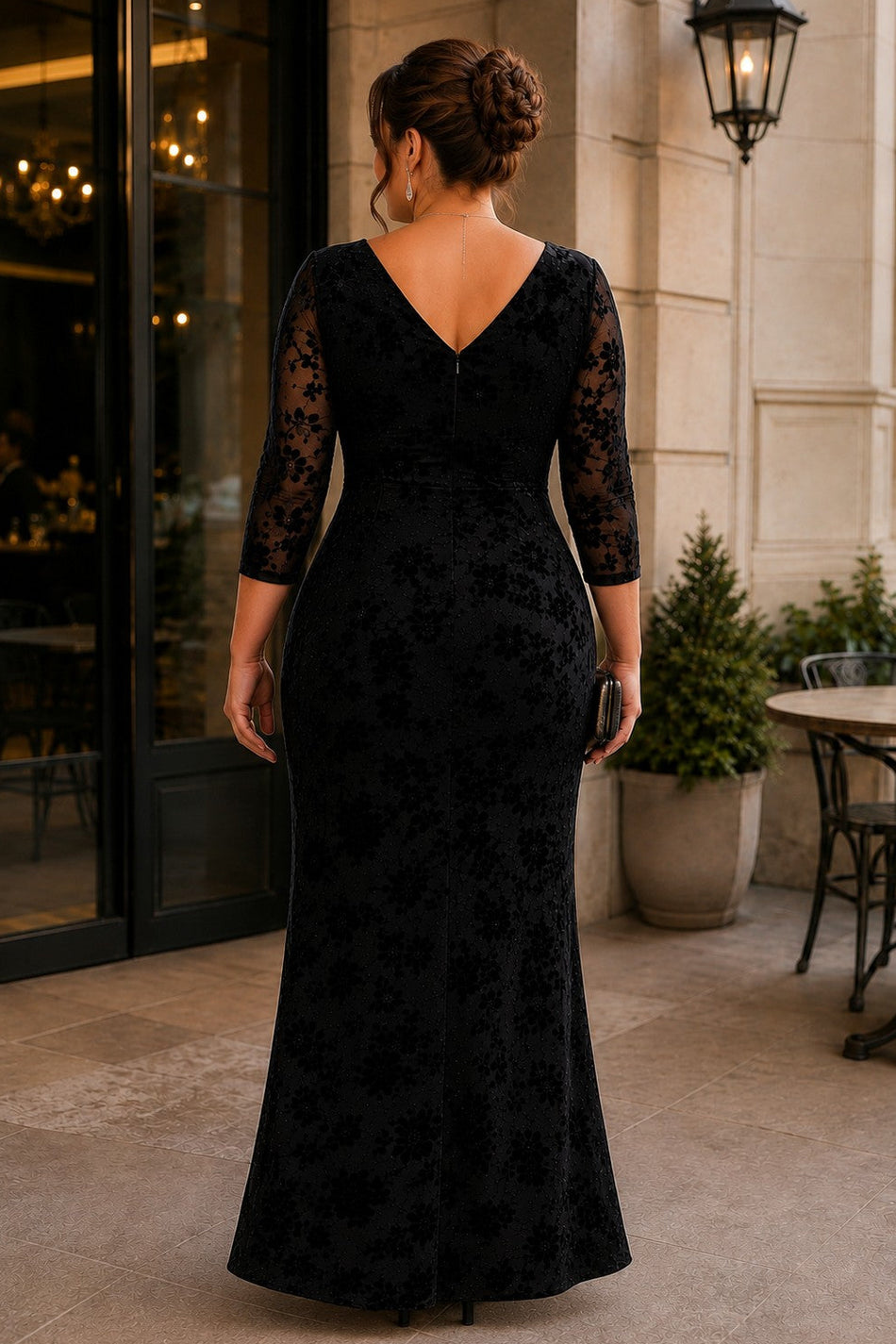 Back view of a plus size black floral maxi formal dress with V-shaped back, sheer three-quarter sleeves and floor-length skirt.