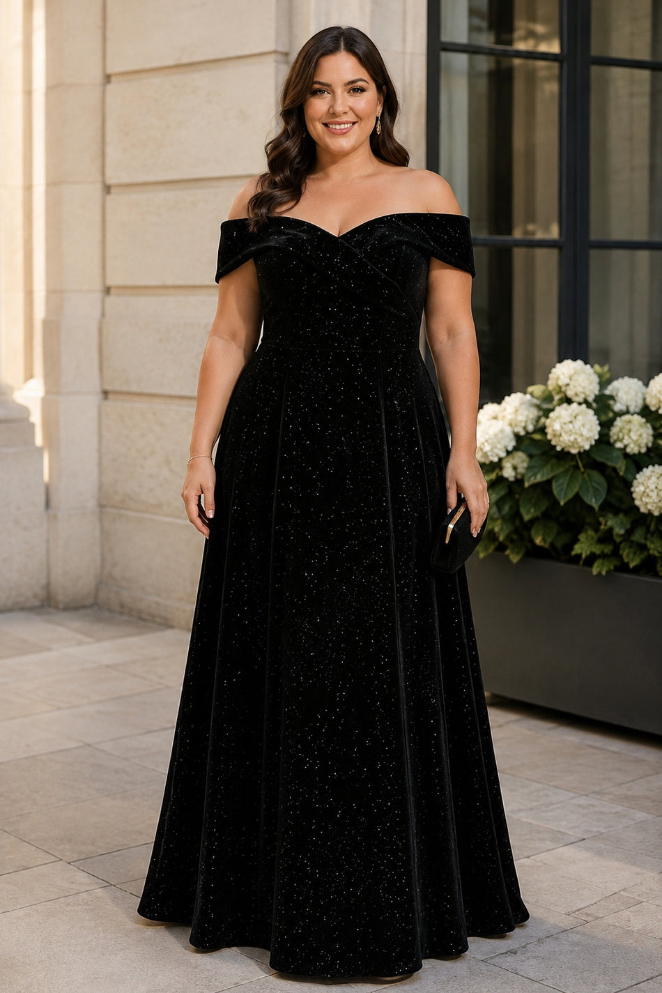 Plus size woman wearing a black off-shoulder evening dress with crossover neckline, defined waist and full-length A-line skirt.