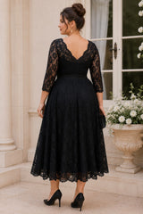 Back view of a plus size black lace midi dress with deep V back, three-quarter lace sleeves and scalloped hem.