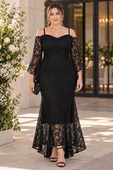 Plus size woman wearing a black lace evening dress with sweetheart neckline, cold-shoulder flared sleeves and long sheer lace hem.