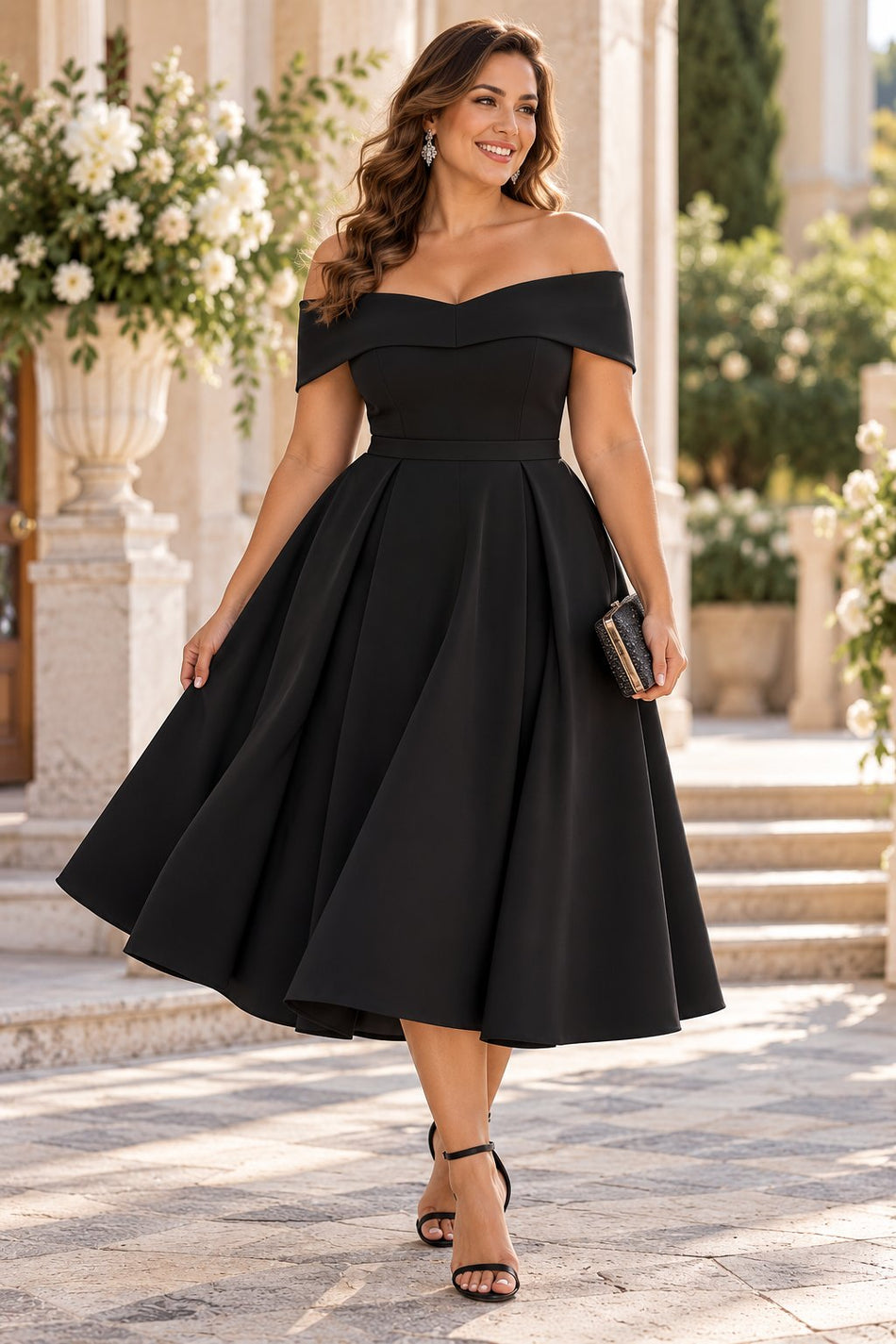 Woman wearing a black off shoulder cocktail midi dress with a sweetheart neckline and full below-the-knee skirt.