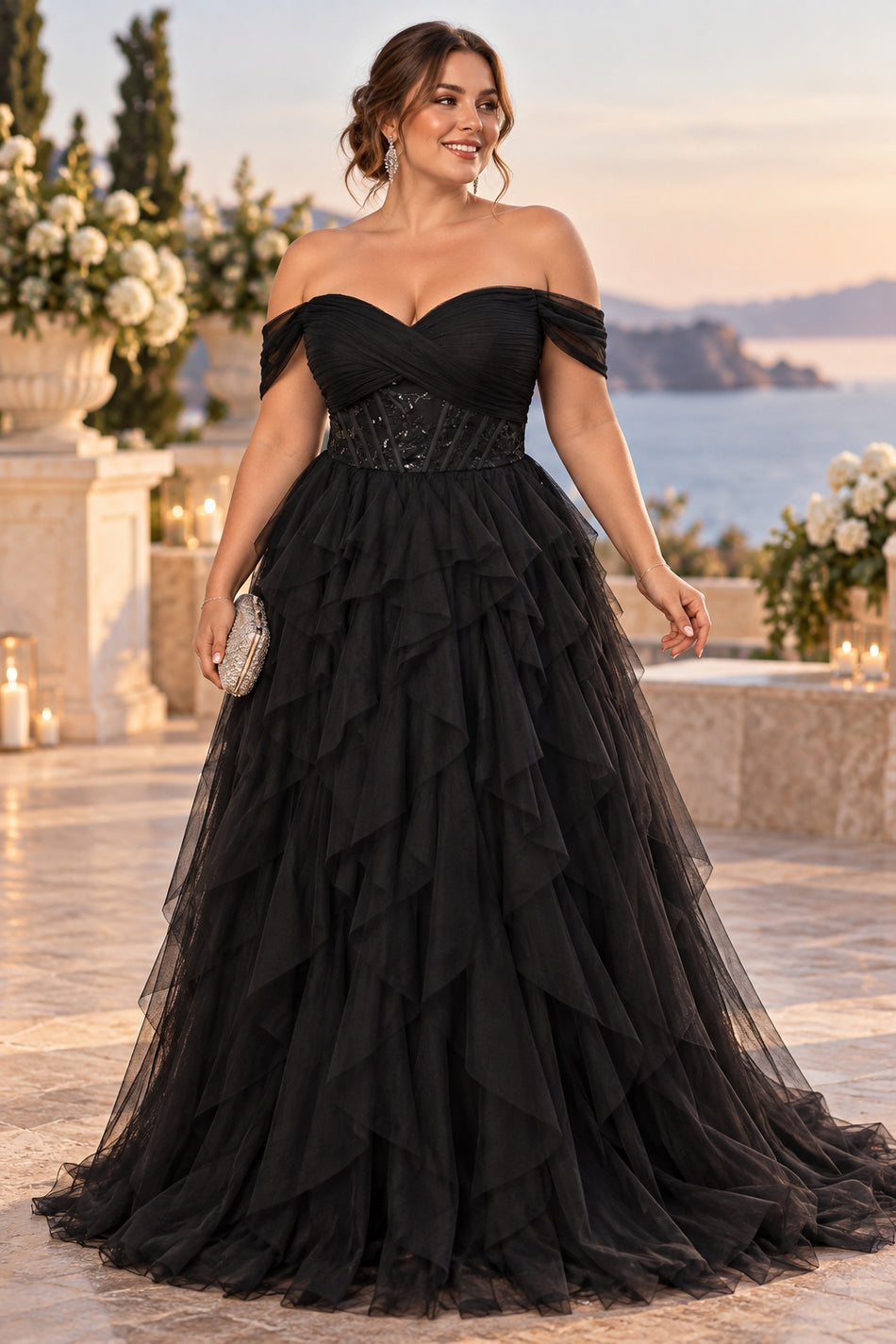 Plus size woman wearing a black off shoulder tulle formal gown with a fitted embellished waist and cascading full-length skirt.