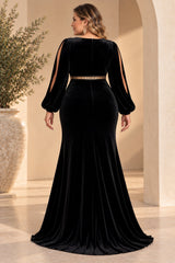 Back view of a plus size woman wearing a black velvet evening dress with long split sleeves, defined gold-toned waist and flared floor-length skirt.