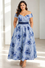 Front view of a blue floral plus size wedding guest dress with an off shoulder neckline and flowing midi skirt.