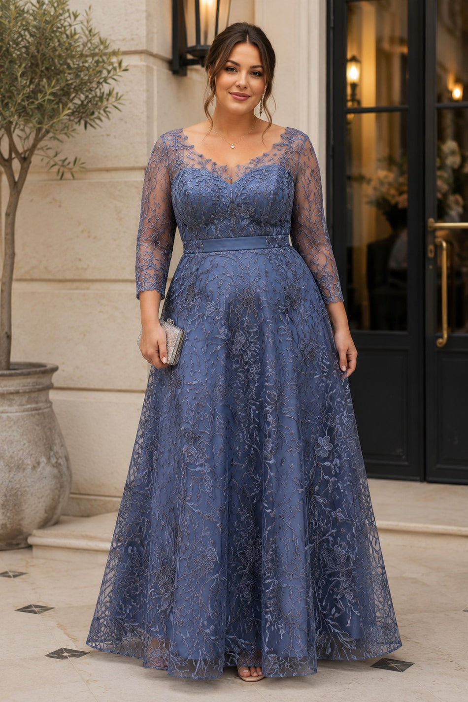 Front view of a plus size blue lace formal dress featuring an illusion sweetheart neckline, sheer three-quarter sleeves and a flowing A-line maxi skirt.