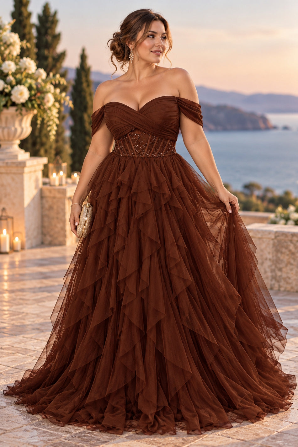 Plus size woman wearing a brown off shoulder tulle formal gown with a draped bodice, defined waist and cascading layered skirt.