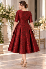 Back view of burgundy floral jacquard midi dress showing the high back neckline, fitted waist and full A-line skirt.
