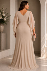 Back view of a plus size woman wearing a champagne wrap evening dress with V neckline, cape sleeves and cascading front drape.