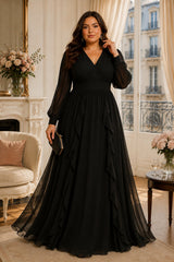 Front view of a plus size chiffon maxi evening dress with long sheer sleeves, wrap V-neckline, empire waist and a line with ruffles in black.