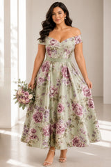 Plus size woman wearing a sage green floral off shoulder A-line midi wedding guest dress with a defined waist.