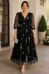 Plus Size Floral Wedding Guest Midi Dress in Black with wrap V-neckline, floral embroidery and sheer sleeves.