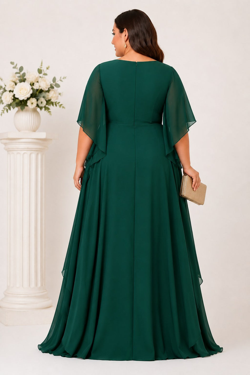 Back view of an emerald green plus size chiffon formal maxi dress with flowing angel sleeves and layered maxi skirt.