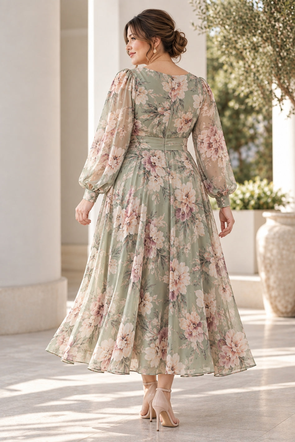 Back view of a sage green floral midi dress with long sheer sleeves, defined waistband and flowing A-line skirt.