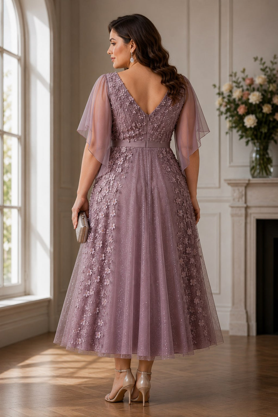 Back view of a plus size mauve floral formal midi dress featuring a V-back, flutter sleeves and elegant floral appliqué.