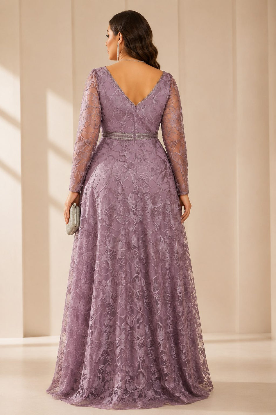 Back view of plus size mauve embroidered lace formal evening gown featuring a V-back neckline, long sheer sleeves, decorative waistband and flowing A-line skirt.