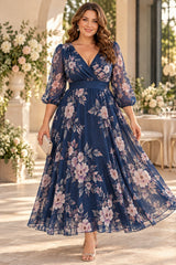 Plus size woman wearing a navy floral maxi dress with a wrap V-neckline, sheer three-quarter sleeves and flowing A-line skirt.