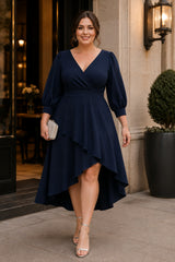Front view of a navy plus size wedding guest dress with wrap neckline, three-quarter sleeves and flowing high-low skirt.