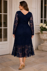 Back view of navy plus size lace wedding guest dress with V-shaped neckline, sheer long sleeves and flared lace hem.