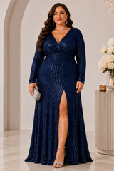 Plus size woman wearing a navy sequin evening dress with V neckline, long sleeves, gathered waist and front slit.