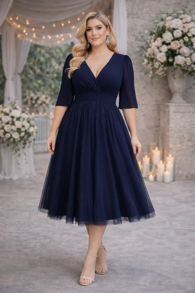 Plus size navy tulle midi dress with V neckline and flutter sleeves, flattering empire waist fit for wedding guest occasions