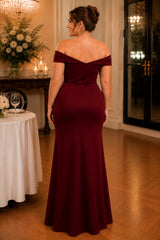Plus size woman wearing a burgundy off shoulder evening gown with a high waist and full-length fit-and-flare silhouette.