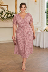 Plus size pink polka dot ruched midi dress with V-neck, short sleeves and flowing A-line skirt.