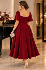 Back view of a red midi cocktail dress with pearl-trimmed square back, flutter sleeves and full fit-and-flare skirt.