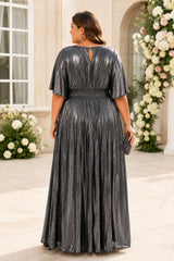 Back view of a silver metallic pleated wedding guest maxi dress with dolman sleeves and keyhole back detail.