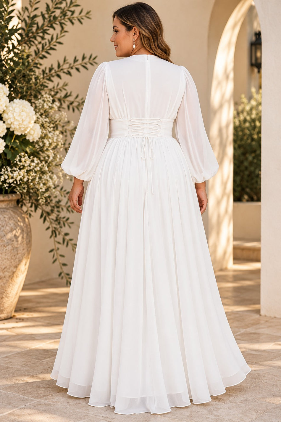 Back view of a plus size white long sleeve maxi dress with lace-up waist detail and flowing floor-length skirt.