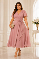 Plus size wrap midi dress with flutter sleeves, waist tie and flowing A-line skirt in blush pink.